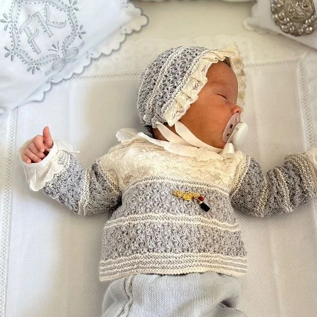 Carmen Varona Moda Infantil bebe en cuna con traje azul